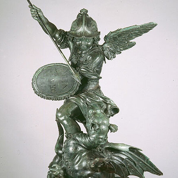 Eine bewaffnete Engelsfigur aus Bronze, die über einem Drachen steht.