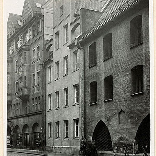 historische Schwarzweiß-Fotografie von drei verschiedenen aneinanderliegenden Gebäudefassaden.
