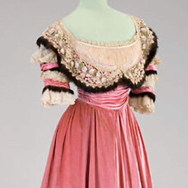 Historisches bodenlanges Kleid in Rosa mit heller Spitze und schmalen braunen Pelzbesätzen.