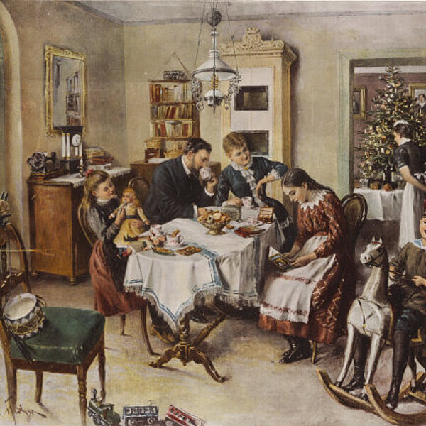 Eltern mit ihren drei Kindern am Frühstückstisch sitzend, im Hintergrund schaut sich eine Hausangestellte den Weihnachtsbaum im Nebenzimmer an